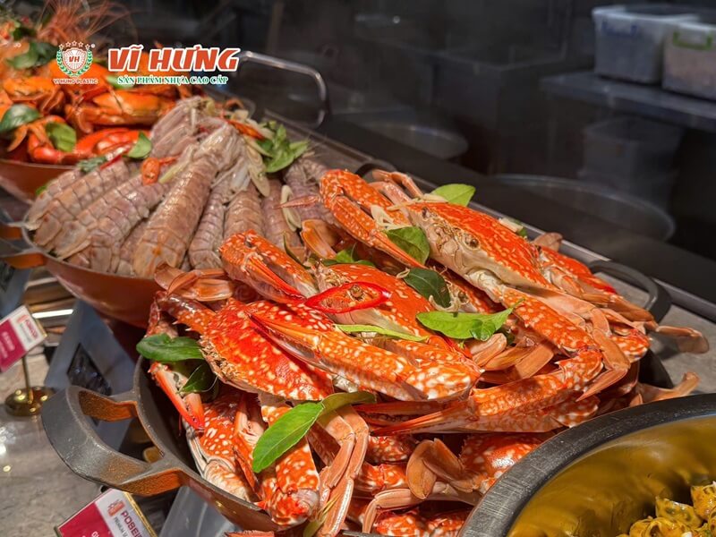 Quầy buffet hải sản với nhiều khay cua biển hấp chín đỏ tươi được bày tại nhà hàng cao cấp