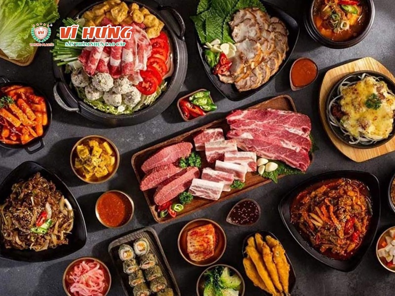 Bàn lẩu nướng gọi món đầy đủ với các đĩa thịt bò, hải sản, rau củ và nồi lẩu được bày biện đẹp mắt trên bàn tối.