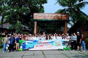 Cả đoàn chụp chung, biển xanh phía sau